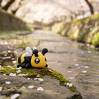 Buzzly – 3D-gedruckte Biene, Lifestyle-Foto mit Insektenhotel und Kamillenblüten