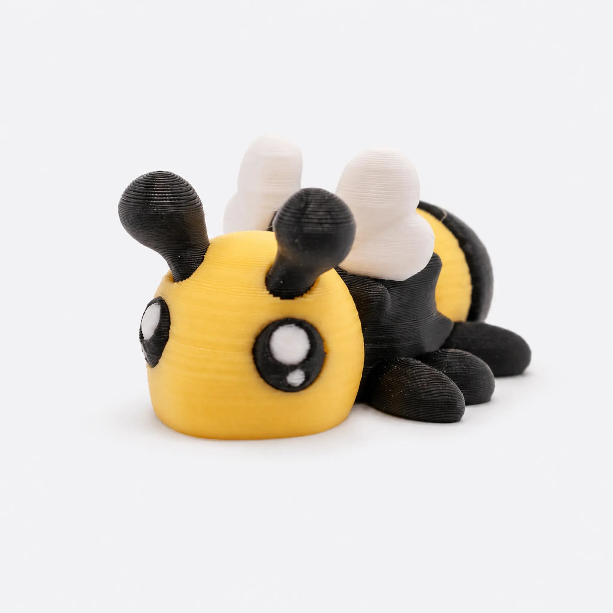 Buzzly – bewegliche 3D-gedruckte Biene in Gelb, Schwarz und Weiß vor hellem Studiohintergrund